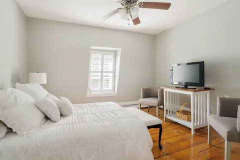 a bedroom with two beds and wooden floor