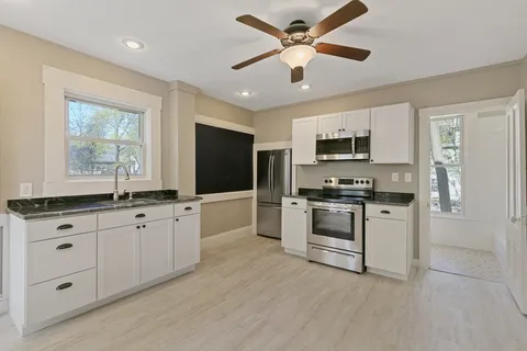 a view of kitchen with sink microwave and refrigerator