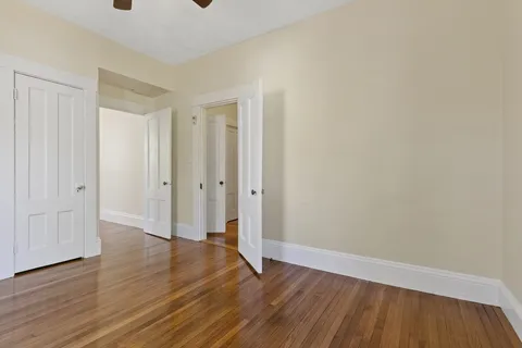 a large tree in front of a white house