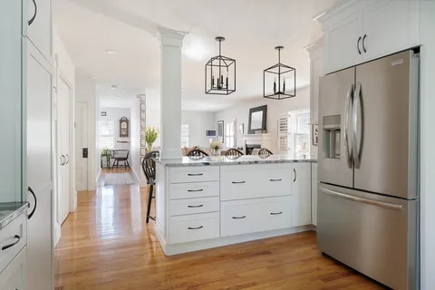 a kitchen with stainless steel appliances a refrigerator and wooden floor