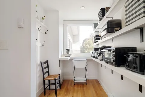 a kitchen with stainless steel appliances a dining table chairs sink and cabinets