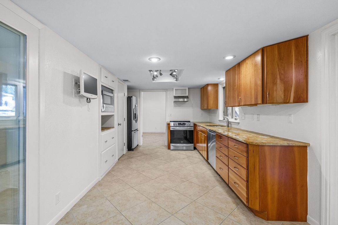 1508 Ben Crenshaw Way Austin, TX 78746 - Photo 12 of 40 a large kitchen with stainless steel appliances granite countertop a refrigerator and a stove