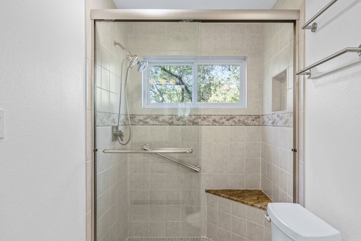 1508 Ben Crenshaw Way Austin, TX 78746 - Photo 18 of 40 a bathroom with a granite countertop bathtub shower sink vanity and toilet