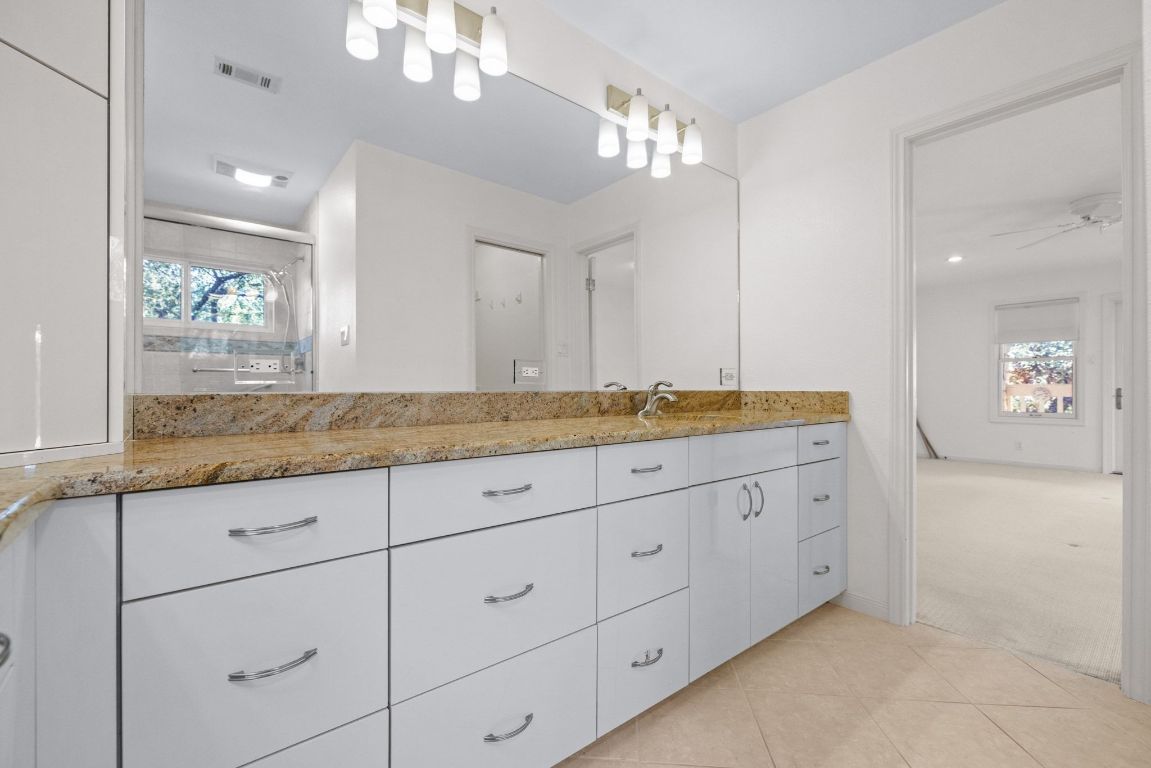 1508 Ben Crenshaw Way Austin, TX 78746 - Photo 19 of 40 a bathroom with double sink and a mirror