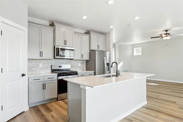 a kitchen with kitchen island a sink stainless steel appliances and cabinets