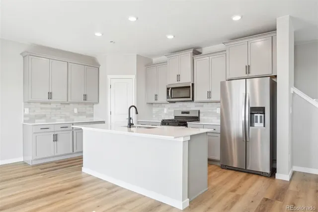 a kitchen with white cabinets sink and refrigerator