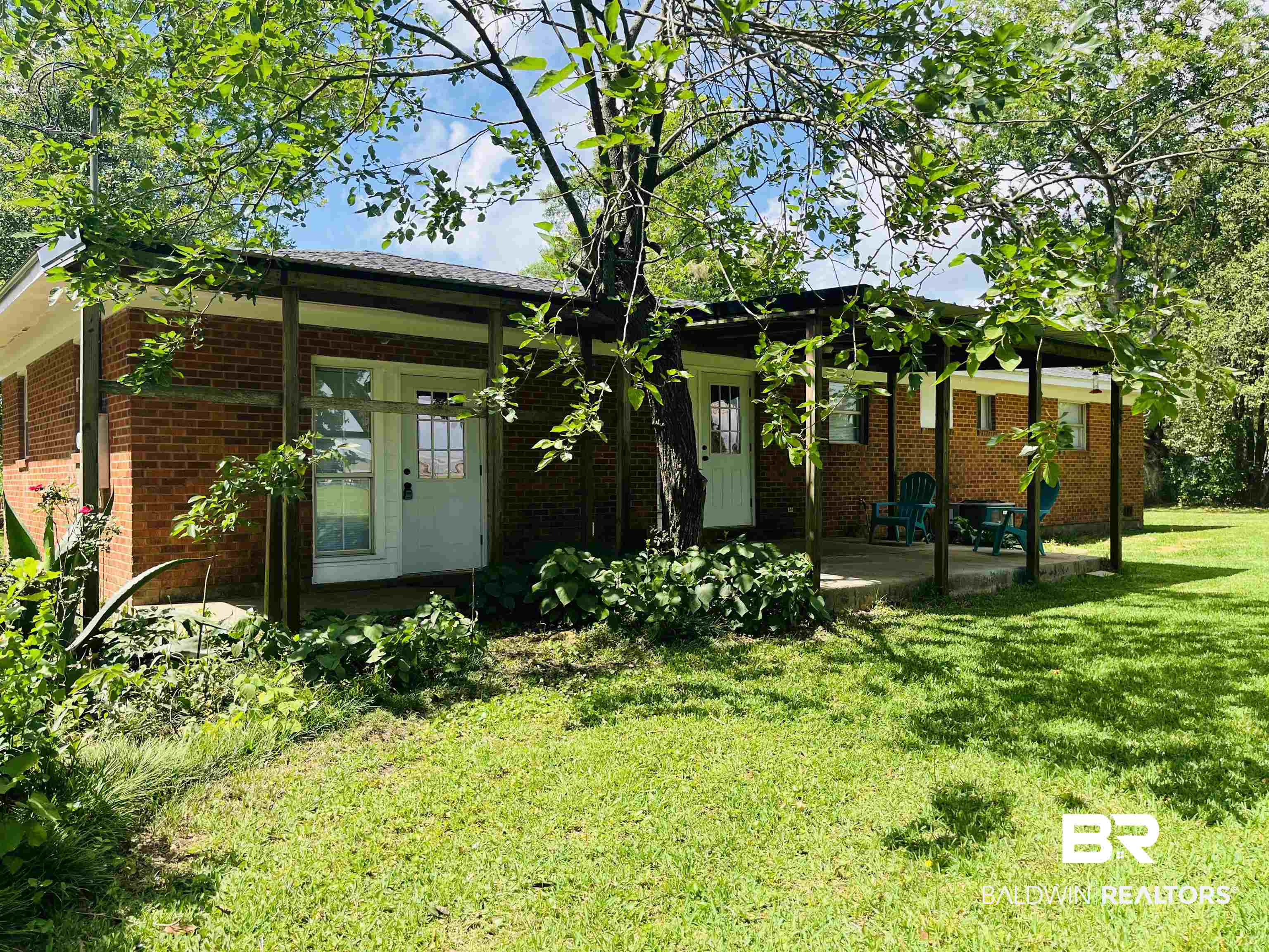 16799 Hinote Glass Road Loxley, AL 36551 - Photo 19 of 26 Back of property with a yard, brick siding, a patio area, and french doors
