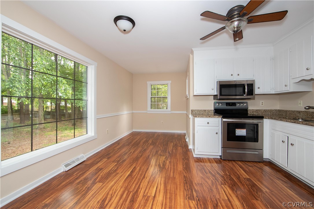 4702 Wilconna Road Chesterfield, VA 23832 - Photo 11 of 27 a kitchen with granite countertop wooden floors a stove and a microwave
