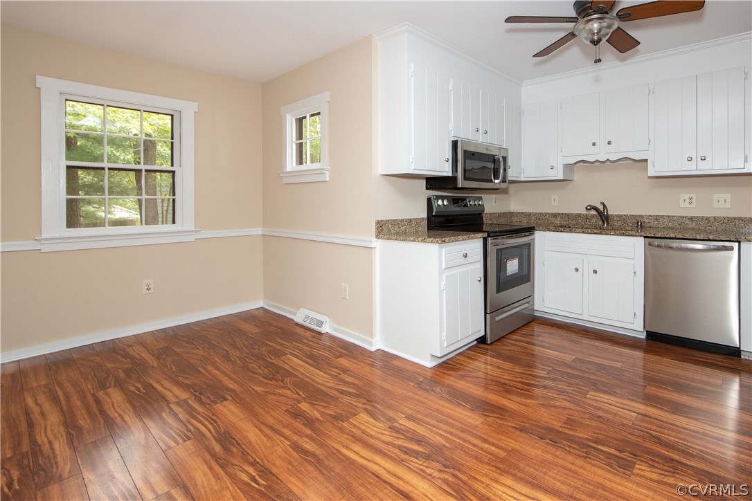 4702 Wilconna Road Chesterfield, VA 23832 - Photo 13 of 27 a kitchen with granite countertop a stove top oven a sink dishwasher and a white cabinets with wooden floor