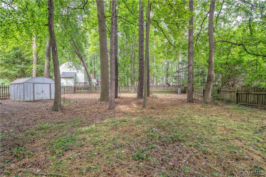 4702 Wilconna Road Chesterfield, VA 23832 - Photo 9 of 27 a backyard of a house with large trees and wooden fence