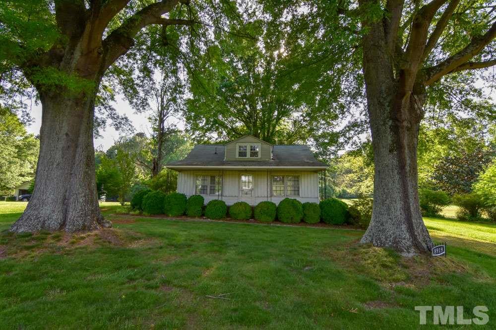 8919 North Roxboro Road Bahama, NC 27503 - Photo 21 of 26 a view of a house with a tree in a yard