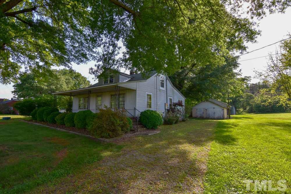 8919 North Roxboro Road Bahama, NC 27503 - Photo 5 of 26 a view of a house with a yard and a large tree