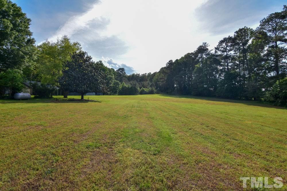 8919 North Roxboro Road Bahama, NC 27503 - Photo 6 of 26 a view of a swimming pool and trees in the background
