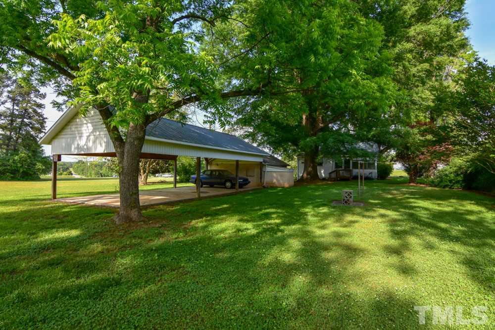 8919 North Roxboro Road Bahama, NC 27503 - Photo 10 of 26 a front view of a house with garden