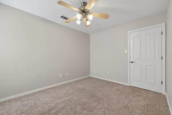 a view of an empty room with a ceiling fan and a window