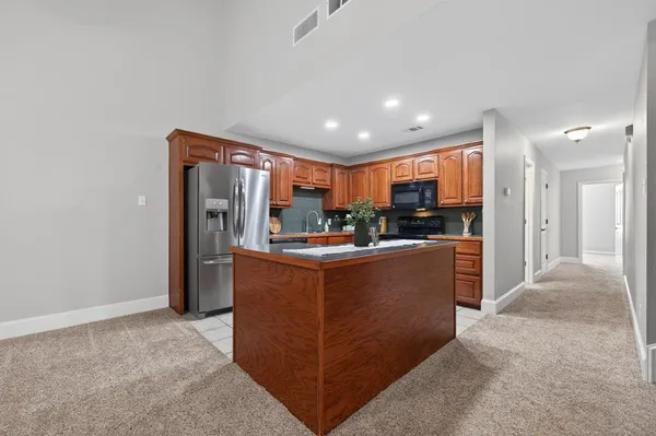 a kitchen with stainless steel appliances granite countertop a refrigerator and a stove
