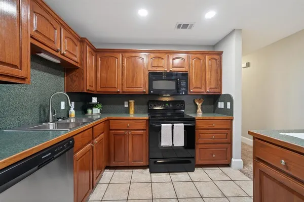 a kitchen with stainless steel appliances granite countertop a stove sink and cabinets