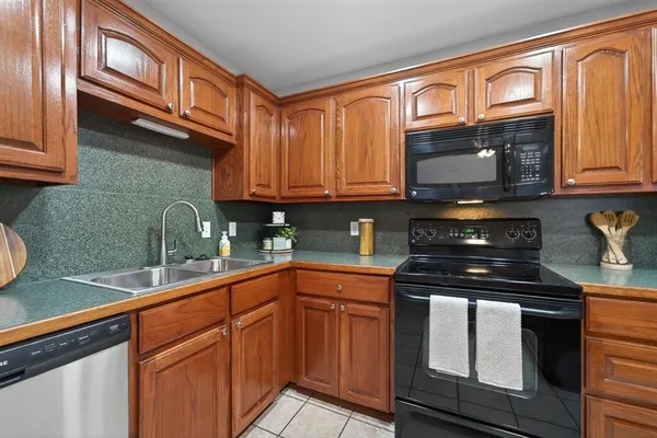 a kitchen with granite countertop cabinets stainless steel appliances and a sink