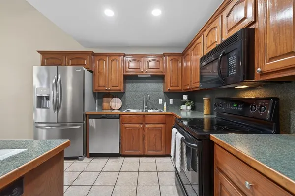 a kitchen with stainless steel appliances granite countertop a refrigerator stove and sink