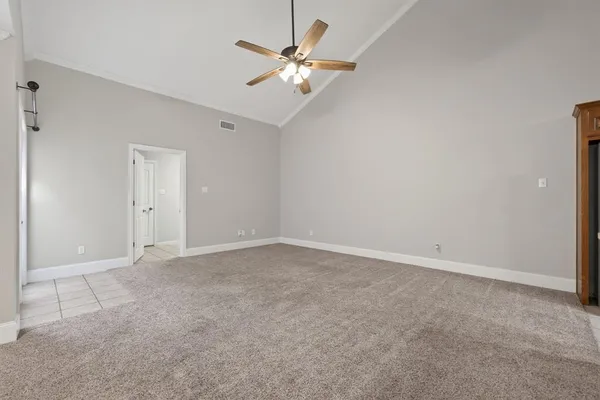 an empty room with closet and ceiling fan