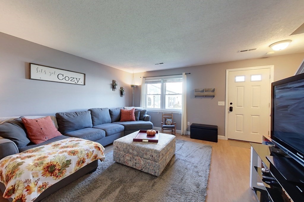 103 Main Street, Unit 16 Pepperell, MA 01463 - Photo 13 of 33 a living room with furniture and a flat screen tv