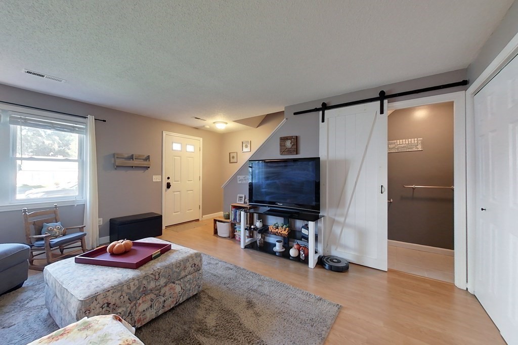 103 Main Street, Unit 16 Pepperell, MA 01463 - Photo 14 of 33 a living room with furniture and a flat screen tv