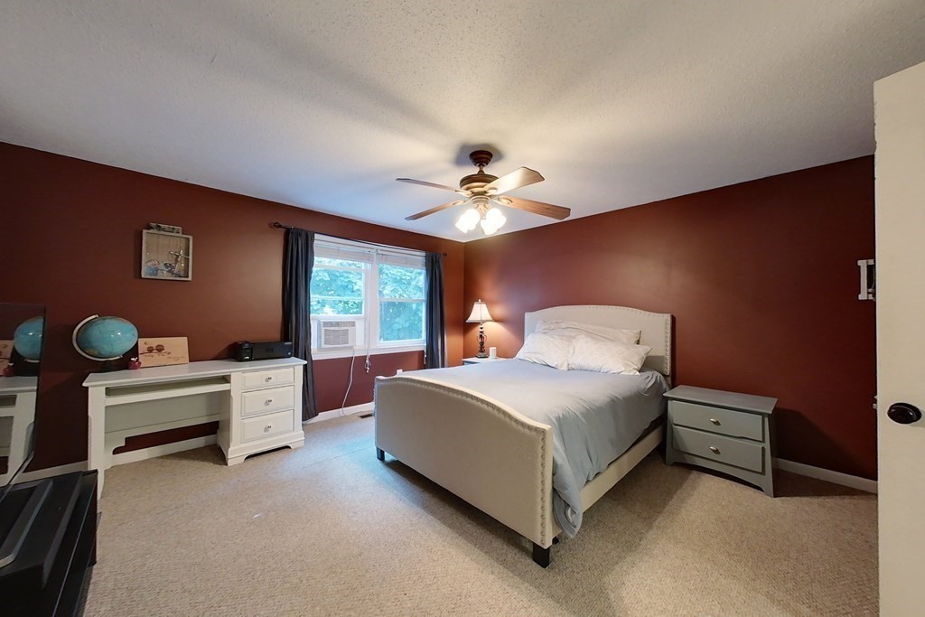 103 Main Street, Unit 16 Pepperell, MA 01463 - Photo 17 of 33 a spacious bedroom with a bed and a chandelier