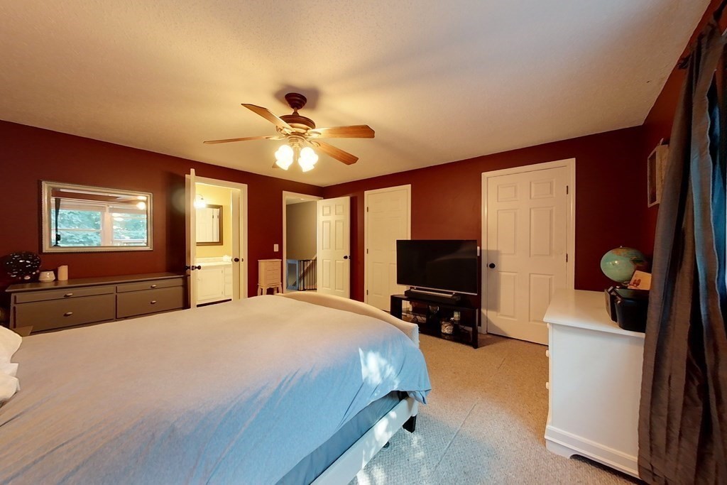 103 Main Street, Unit 16 Pepperell, MA 01463 - Photo 19 of 33 a bedroom with a bed and a flat tv screen on dresser