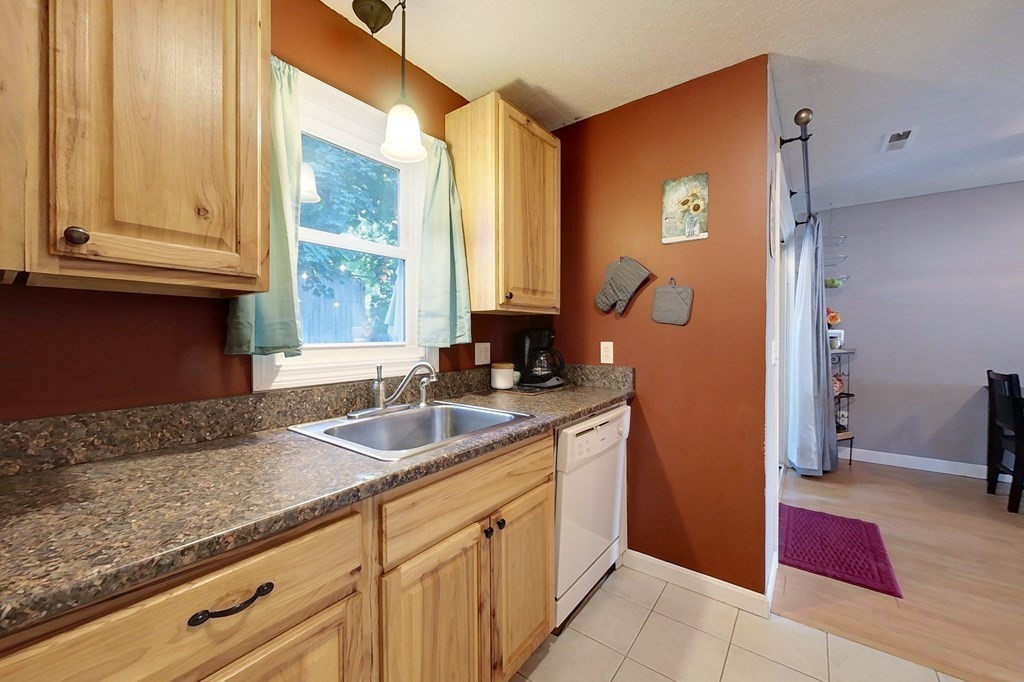 103 Main Street, Unit 16 Pepperell, MA 01463 - Photo 4 of 33 a kitchen with sink cabinets and outdoor view