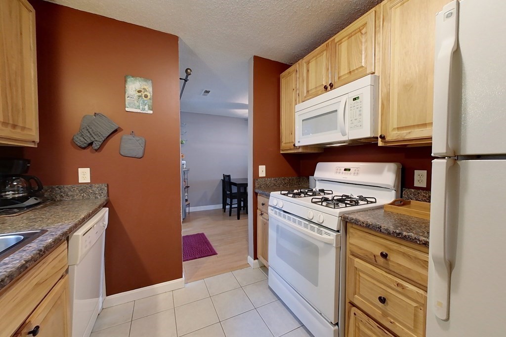 103 Main Street, Unit 16 Pepperell, MA 01463 - Photo 5 of 33 a kitchen with stainless steel appliances granite countertop a stove a refrigerator and a microwave