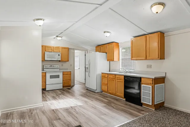 a large kitchen with stainless steel appliances a stove a sink dishwasher and a refrigerator