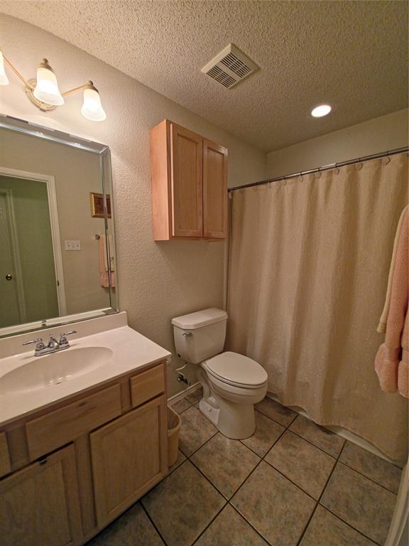 514 Pinto Lane Forney, TX 75126 - Photo 18 of 28 a bathroom with a sink a toilet a mirror and shower curtain