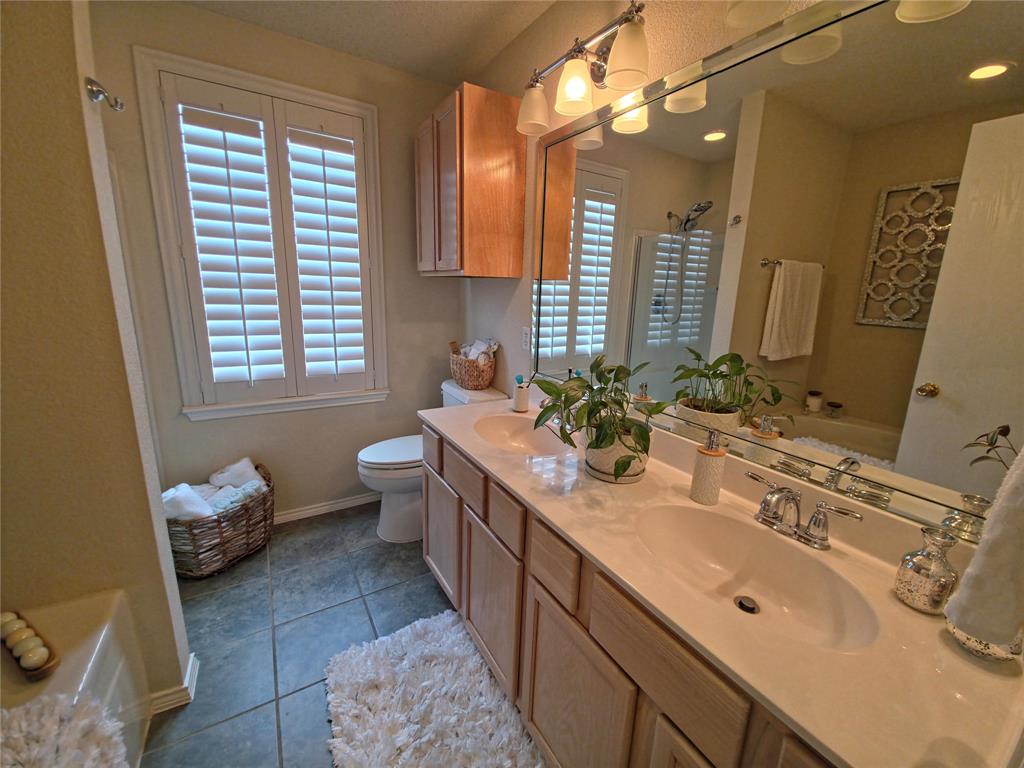 514 Pinto Lane Forney, TX 75126 - Photo 21 of 28 a spacious bathroom with a double vanity sink mirror and a toilet