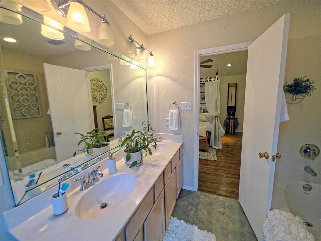 514 Pinto Lane Forney, TX 75126 - Photo 24 of 28 a bathroom with a tub sink and mirror