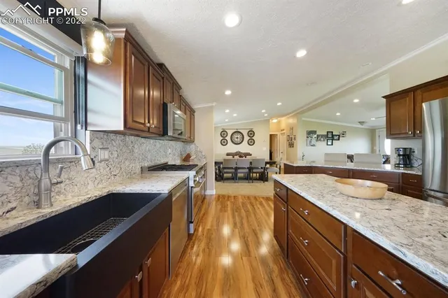a large kitchen with granite countertop a sink and cabinets