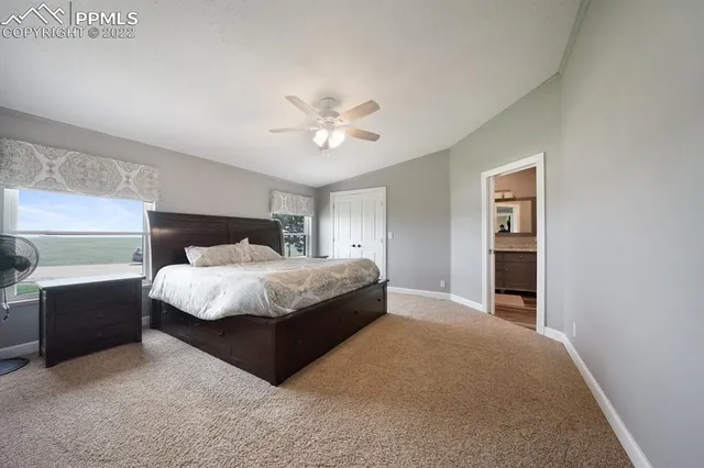 a bedroom with a bed and a ceiling fan