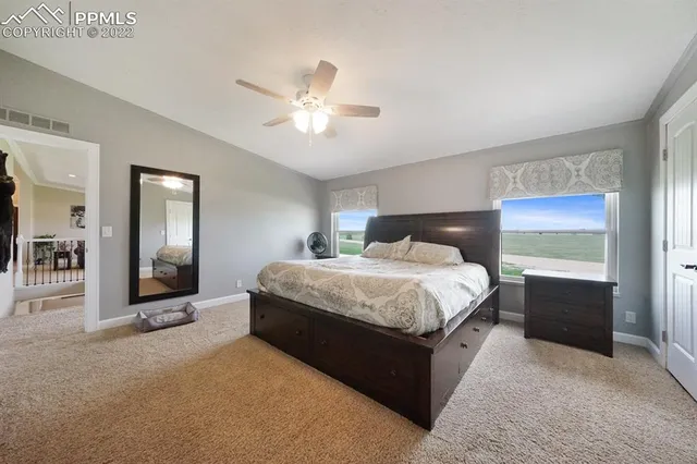 a spacious bedroom with a bed and a chandelier