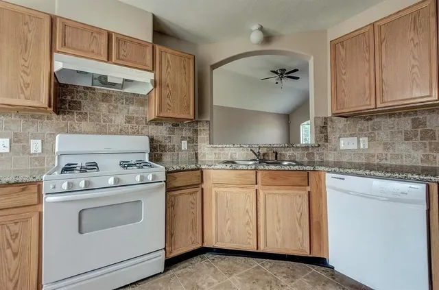 a kitchen with white cabinets white stainless steel appliances and sink