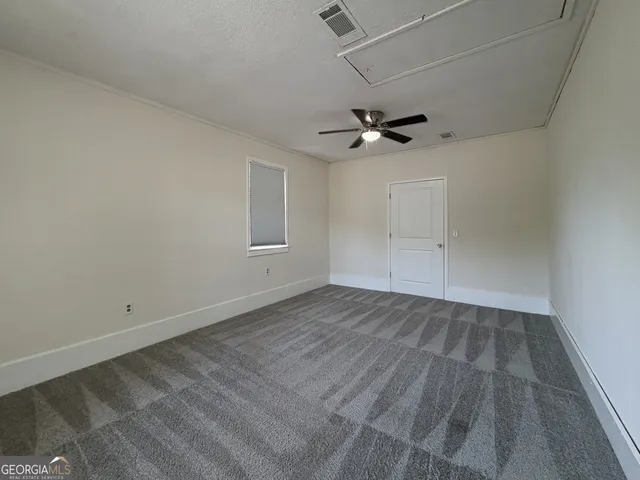 an empty room with a ceiling fan and wooden floor
