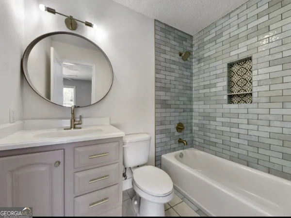 a bathroom with a toilet a sink a mirror and bathtub