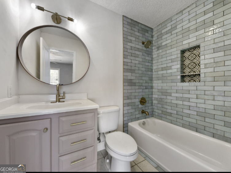 206 Palmetto Street St. Marys, GA 31558 - Photo 16 of 25 a bathroom with a toilet a sink a mirror and bathtub