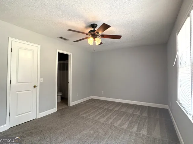 a view of room with window and ceiling fan