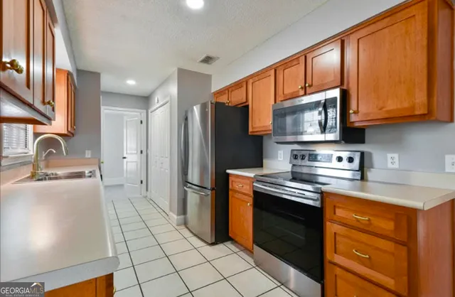 a kitchen with stainless steel appliances granite countertop a refrigerator stove and sink