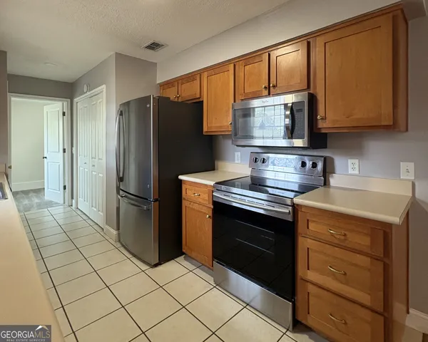 a kitchen with stainless steel appliances granite countertop a stove a refrigerator and a cabinets