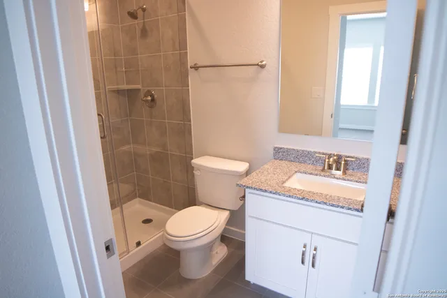 a bathroom with a granite countertop sink toilet and shower