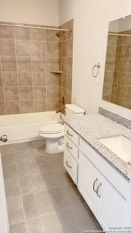 a bathroom with a granite countertop sink a toilet and bathtub