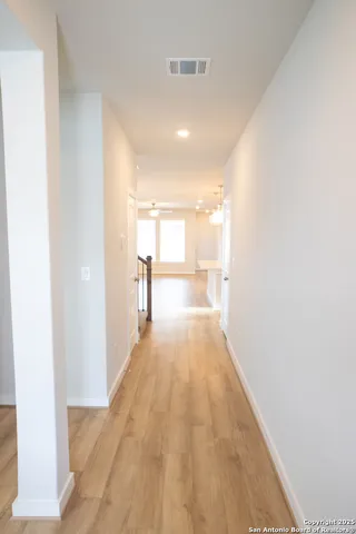 a view of a hallway with wooden floor
