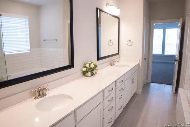a bathroom with double vanity sink and a mirror