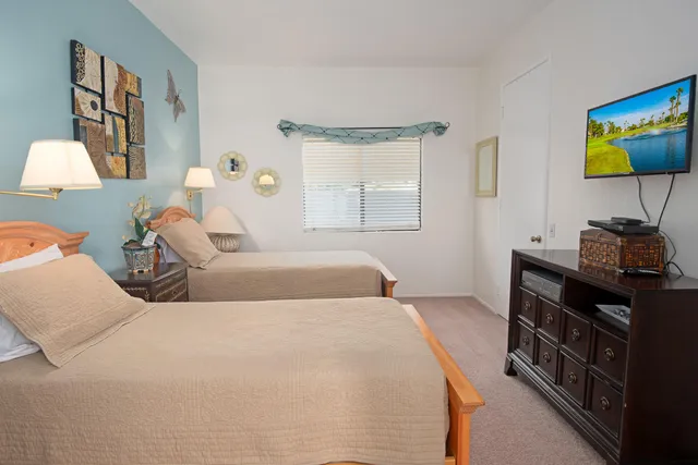 a bedroom with a bed and a lamp on dresser