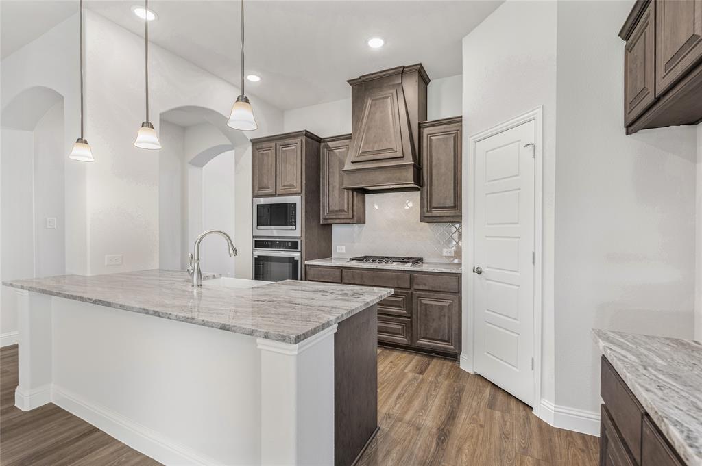 14566 Helena Street Pilot Point, TX 76258 - Photo 11 of 37 a kitchen with stainless steel appliances granite countertop a sink a stove and a refrigerator